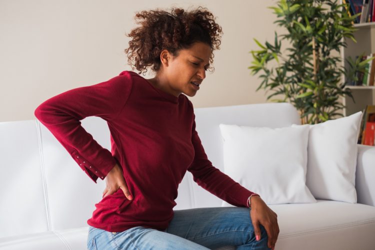 Woman with chronic pain holding back
